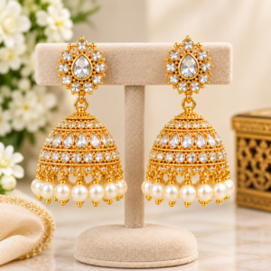 Classic gold-tone jhumkas decorated with sparkling stones and pearl drops for an elegant traditional look.